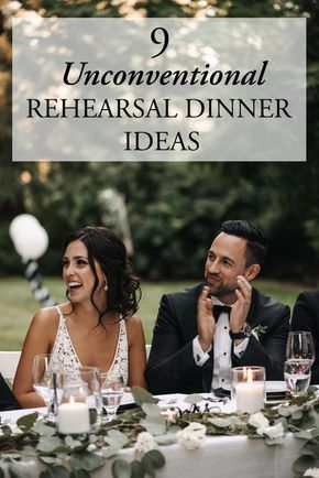 a bride and groom sitting at a table with candles in front of them, laughing