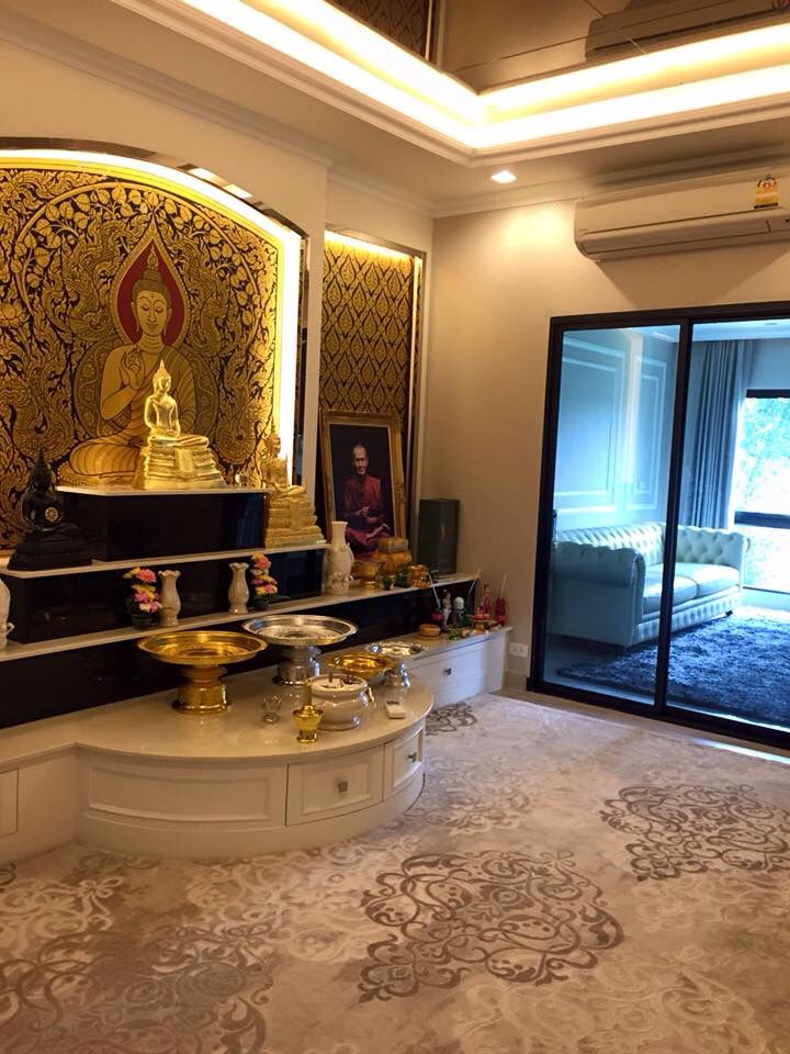 a living room with a buddha statue on the wall