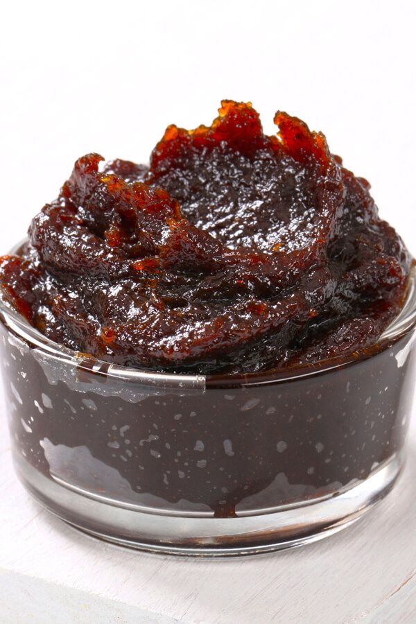 a glass container filled with jam sitting on top of a table