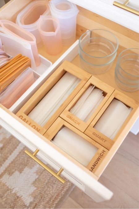 an open drawer in a kitchen with utensils and other items on the drawers