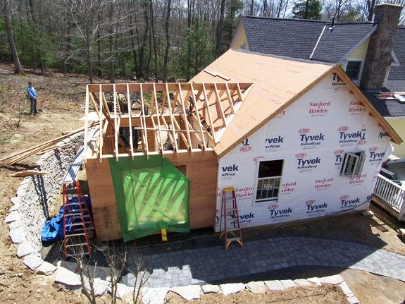 a house being built in the middle of a yard with lots of construction materials around it