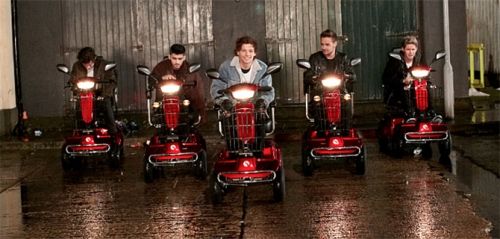 a group of men riding on the backs of vespa scooters with caption saying they see us rollin '