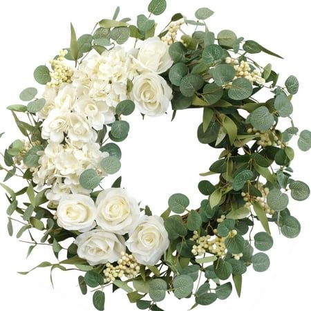 a wreath with white flowers and green leaves