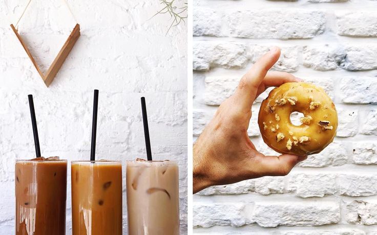 there are three drinks and two donuts in front of the wall, one with chocolate sprinkles on it