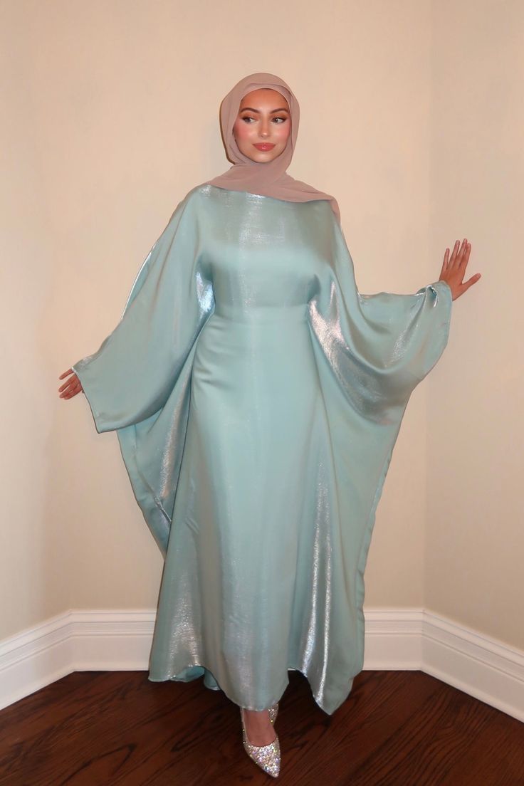 The Turquoise Butterfly Abaya is crafted from an iridescent, lightweight fabric. This piece features a hidden belt inside to create the signature butterfly abaya effect. Its flowing design and delicate shimmer will make you feel effortlessly elegant and confident. ABOUT ME Iridescent, turquoise blue fabric Batwing long sleeves Hidden belt Length: 54” 100% Polyester Made in USA Ethically made CARE Hand Wash Separately Cold No Bleach Line Dry Do Not Iron Steam If Needed Do Not Dry Clean *Follow th Butterfly Abaya Design, Hijabi Fashion Abayas, Cargo Outfits, Butterfly Abaya, Blue Abaya, Abaya Outfit, Turquoise Butterfly, Popular Clothing Styles, Modest Outfit