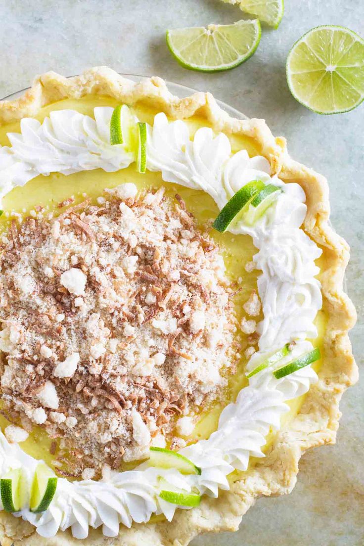 a pie topped with whipped cream and lime slices