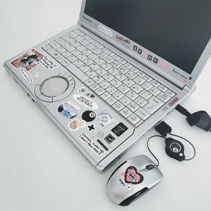 an open laptop computer sitting on top of a white table next to two mouses