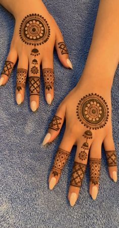 two hands with henna tattoos on them