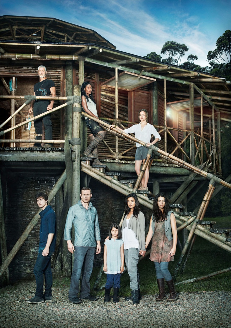 a group of people standing on top of a wooden structure with ladders in front of them