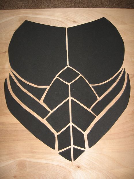 a heart shaped cut out of black paper on a wooden surface with lines drawn across it