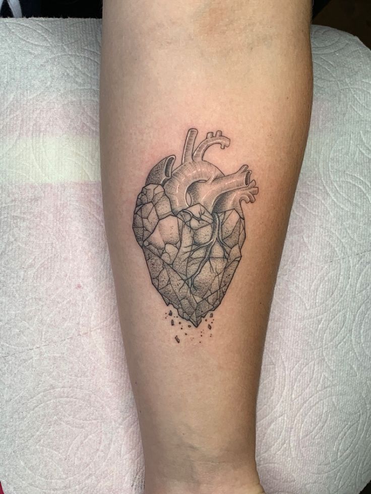 a small heart tattoo on the leg