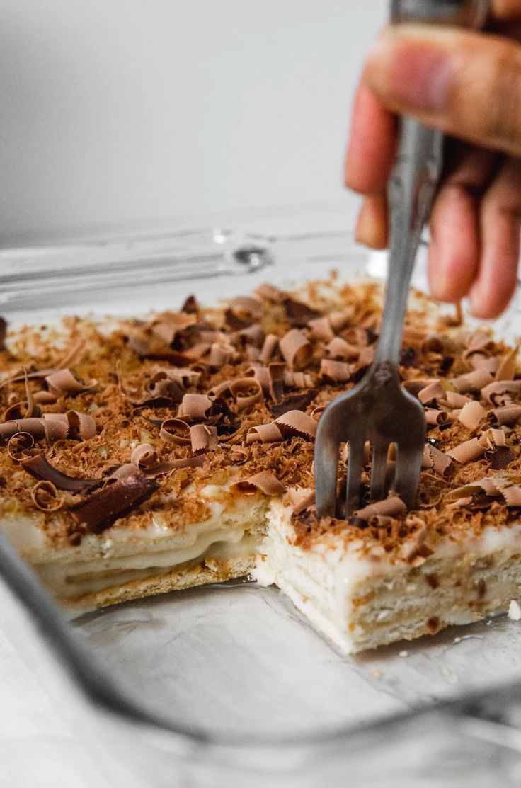 someone is cutting into a dessert with a fork and chocolate shavings on top