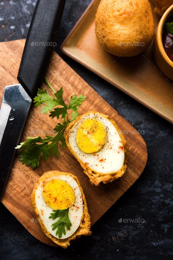 two eggs in bread on a cutting board with parsley - stock photo - images