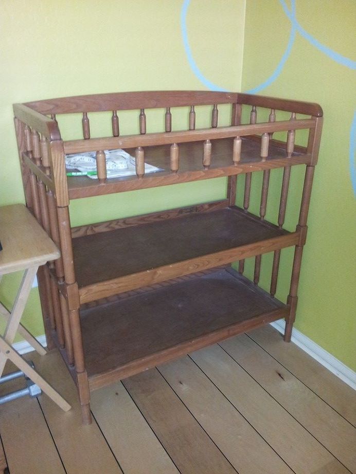 a wooden crib sitting on top of a hard wood floor next to a green wall