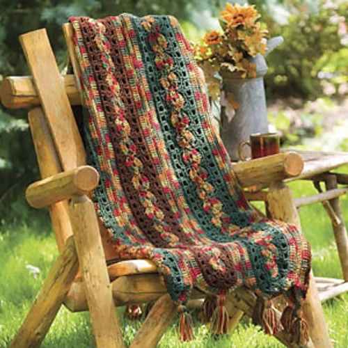 a wooden chair with a crocheted blanket on it