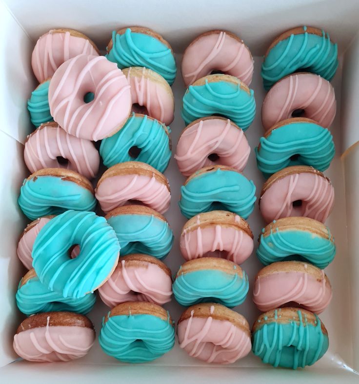 a box filled with pink and blue frosted donuts