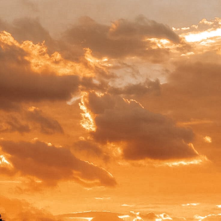 an airplane is flying in the sky at sunset