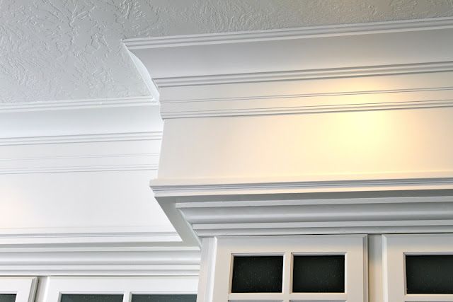 an image of a kitchen with white cabinets and trim around the window sills