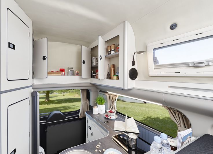 the inside of a camper with an oven, sink and refrigerators in it