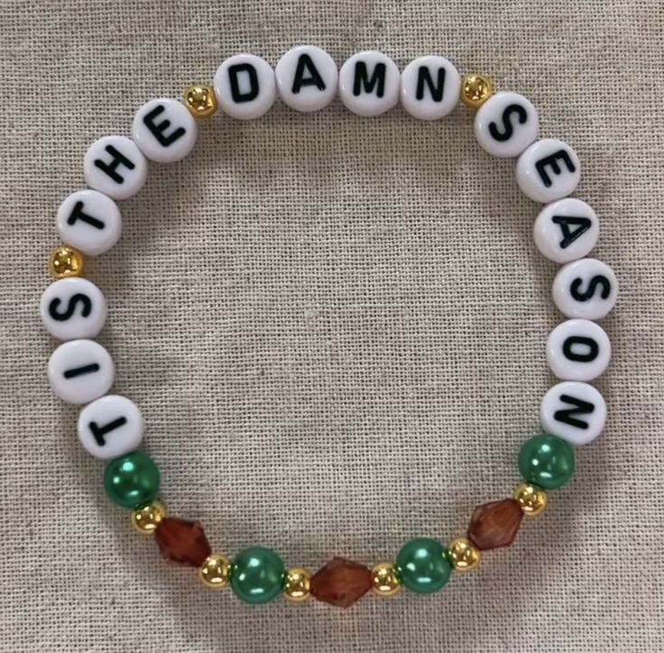 a beaded bracelet with beads and charms on it that says,'the damn season '