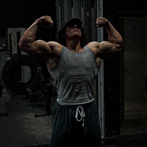 a man with muscles flexing his arms in the gym