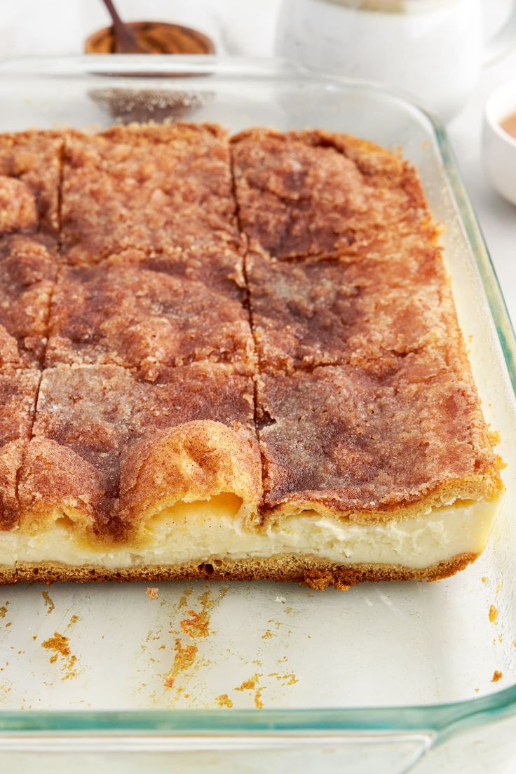 a square casserole dish with some food in the bottom and other dishes on the side