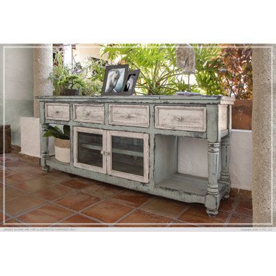 an old dresser is painted white and has potted plants on top