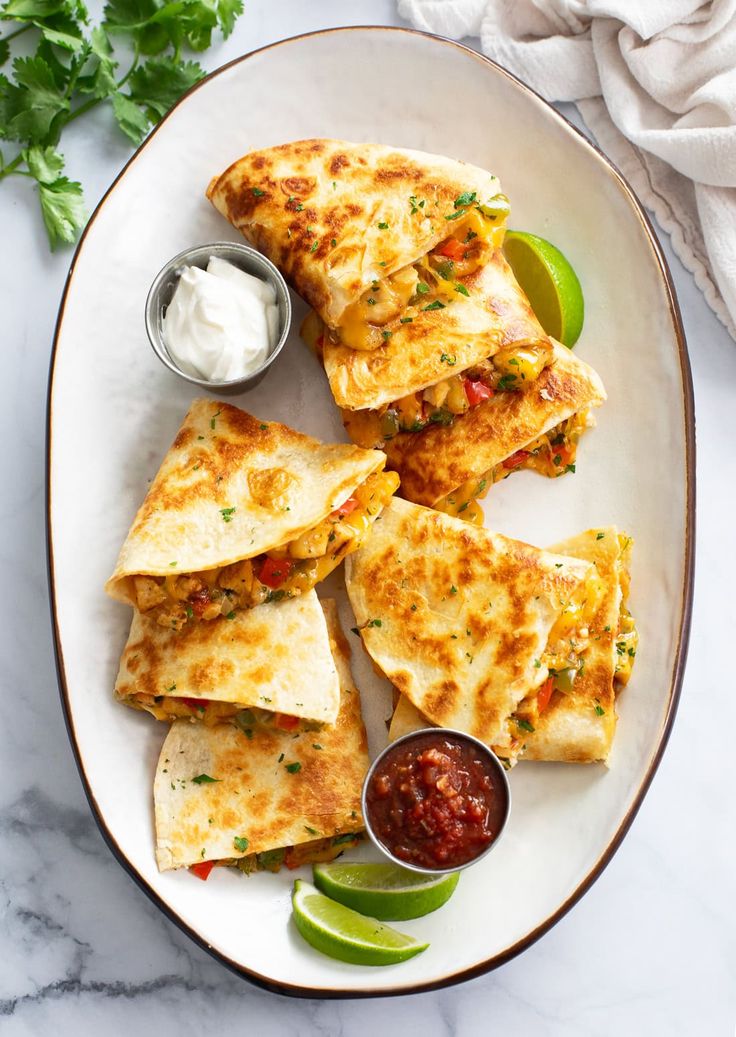 quesadillas on a plate with salsa and sour cream