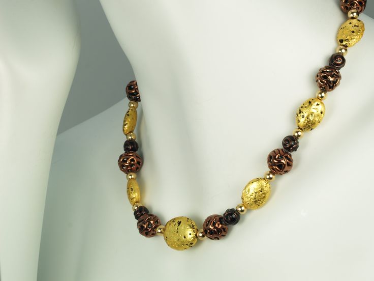 Chocolate Lace Necklace - Hand-Gilded 23-Karat Gold Leaf, Lava Stone, Lampwork Czech Glass, 14-Karat Gold-Filled Toggle Clasp, and Signature Tag I was inspired by finding the shiny open-weave lampwork Czech glass﻿ beads, and of course, thought of my favorite sweet. The glass beads are luxurious with my signature gilded gold on lava stones. The necklace measures 20" (50.8cm), and is dazzling to wear. Check out my Chocolate Lace Bracelet, ﻿a gorgeous combo. See More Home Page Shop Collections Link Chocolate Lace, Lace Bracelet, Lace Necklace, Lace Earrings, Semi Precious Gems, Open Weave, Gold Gilding, Lava Stone, Precious Gems