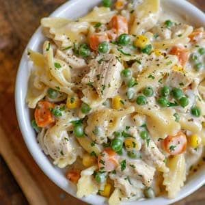 a white bowl filled with pasta and peas