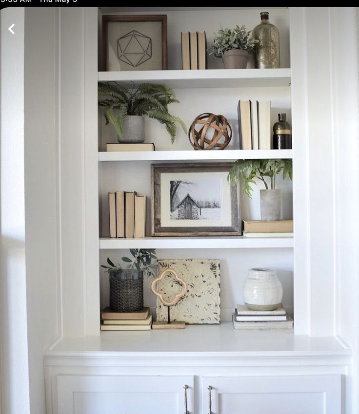 a white book shelf filled with lots of books and other things on top of it