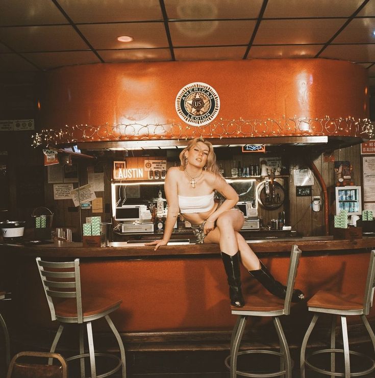 a woman sitting at a bar with her legs crossed