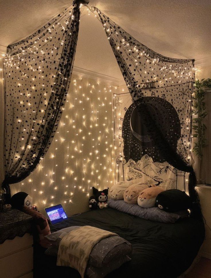 a bedroom decorated with fairy lights and string lights on the walls, along with a bed that has a netted canopy over it