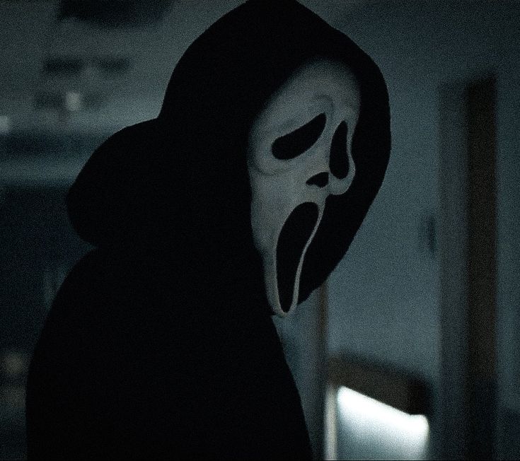 a person wearing a mask in the dark with an evil look on their face and mouth