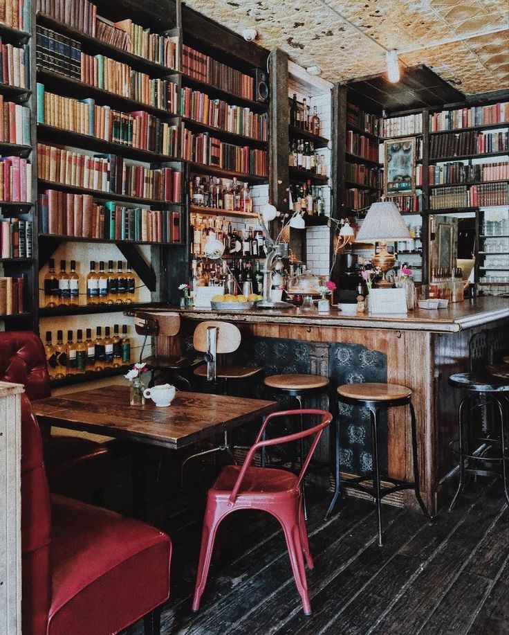 an old fashioned library with many bookshelves full of books and chairs in it