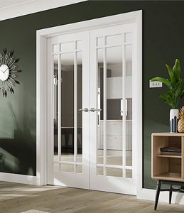 a living room with green walls and white doors