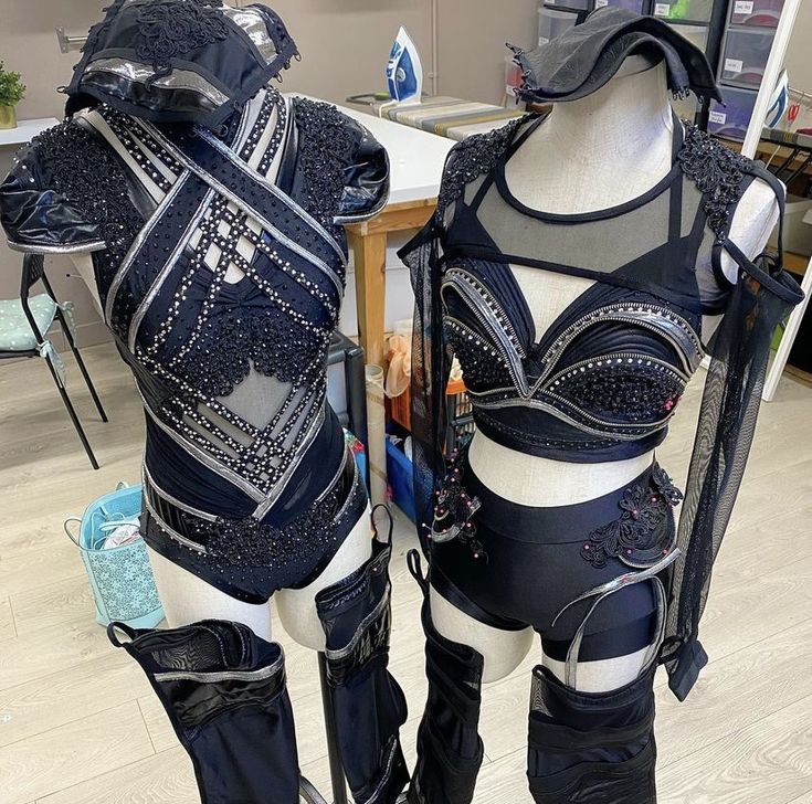 two mannequins dressed in black and white outfits with metal accents on them