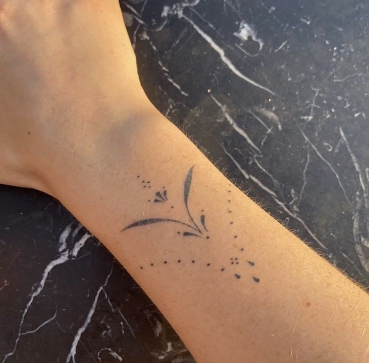 a person's arm with a small tattoo on the left side of their arm