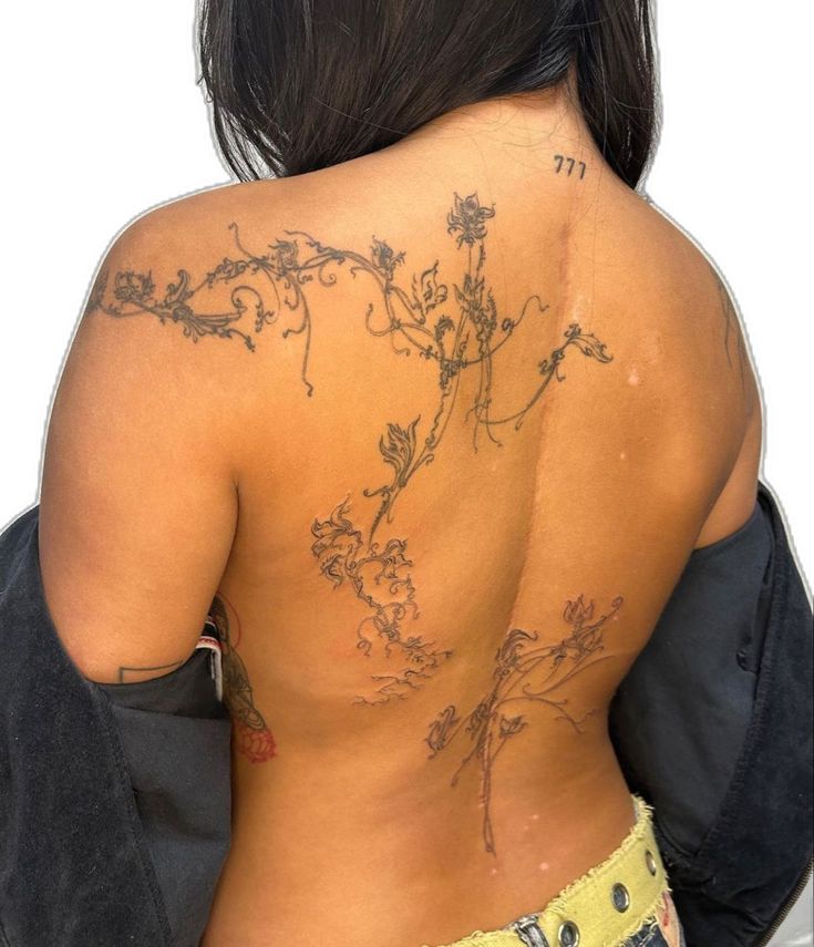 the back of a woman with tattoos on her body