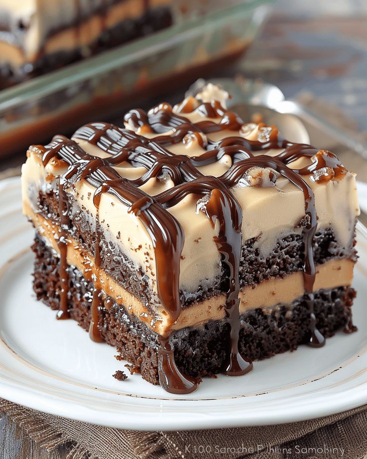 a piece of cake on a white plate with chocolate drizzle and frosting