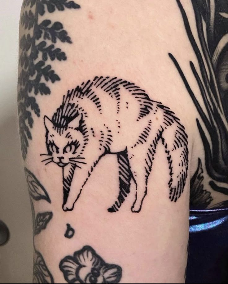 a black and white cat tattoo on the arm