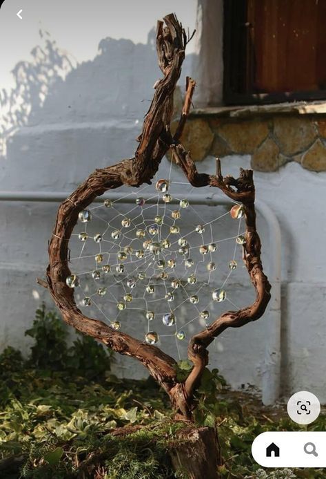 a tree with beads hanging from it's branches in front of a building,