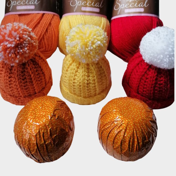 four balls of yarn with pom - poms on them in different colors and sizes