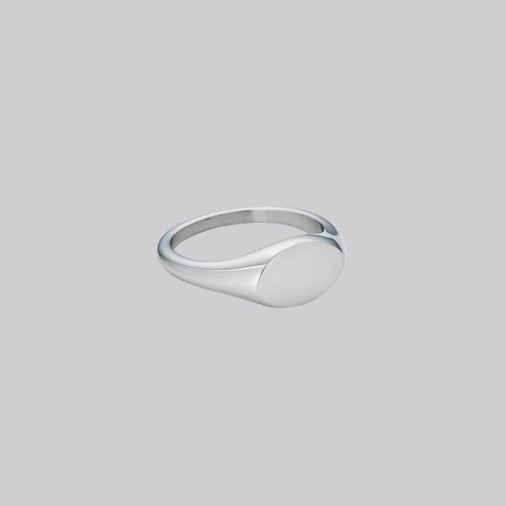 We have designed it to be smaller than a normal signet ring for a minimal and elegant look, yet still retain the classic heirloom appearance. May we suggest it might be a really cute pinky ring? Also available in Gold. Stainless Steel Band Thickness: 2mm-3mm; Oval Width: 11mm; Oval Length:7mm Minimalist White Gold Open Signet Ring, Minimalist Classic Ring Jewelry, Classic Adjustable Ring With Simple Design, Minimalist Classic Design Ring Jewelry, Formal Minimalist Rings With Rounded Edges, Classic Adjustable Midi Rings With Simple Design, Classic Hypoallergenic Ring Jewelry, Classic Hypoallergenic Jewelry Rings, Minimalist White Gold Signet Ring