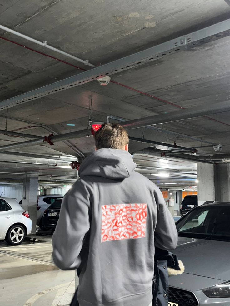 a man in a parking garage with his back to the camera