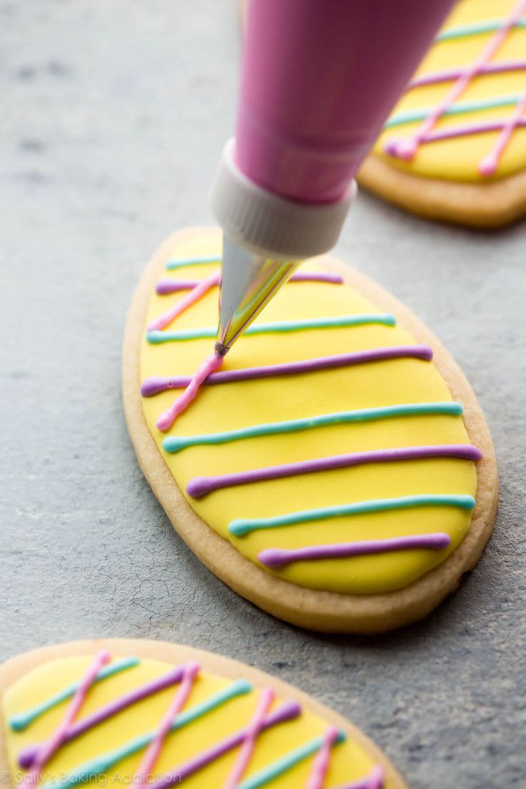 a cookie being decorated with icing and sprinkles