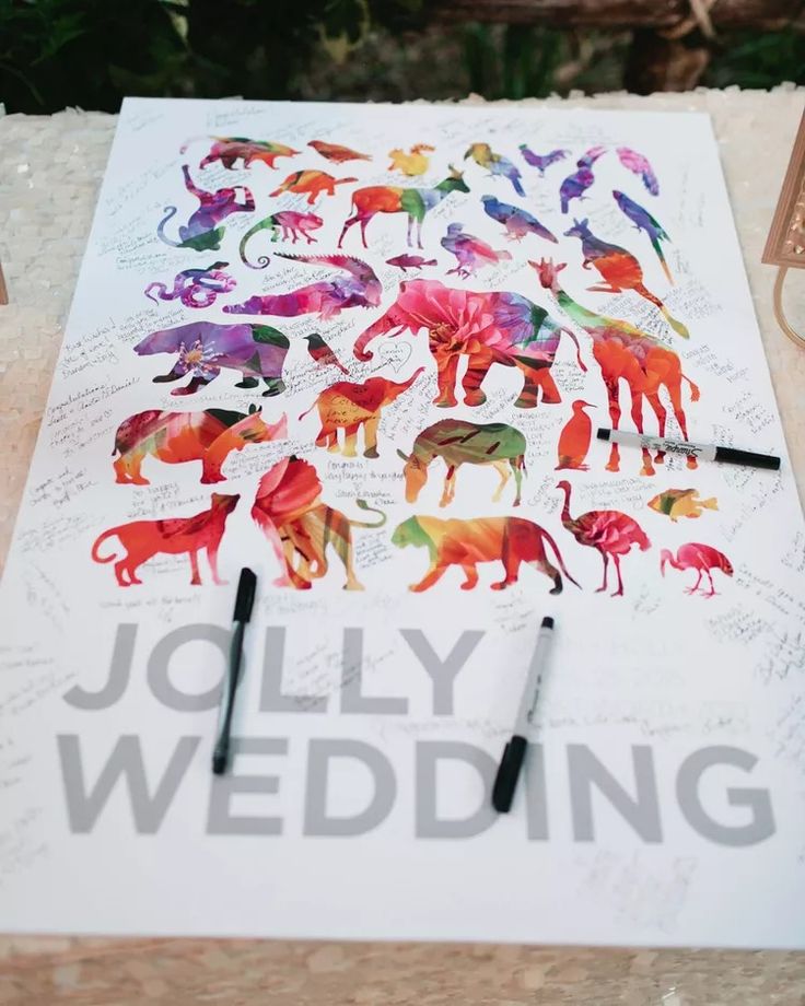 a table topped with lots of different colored animals on top of white paper next to marker pens