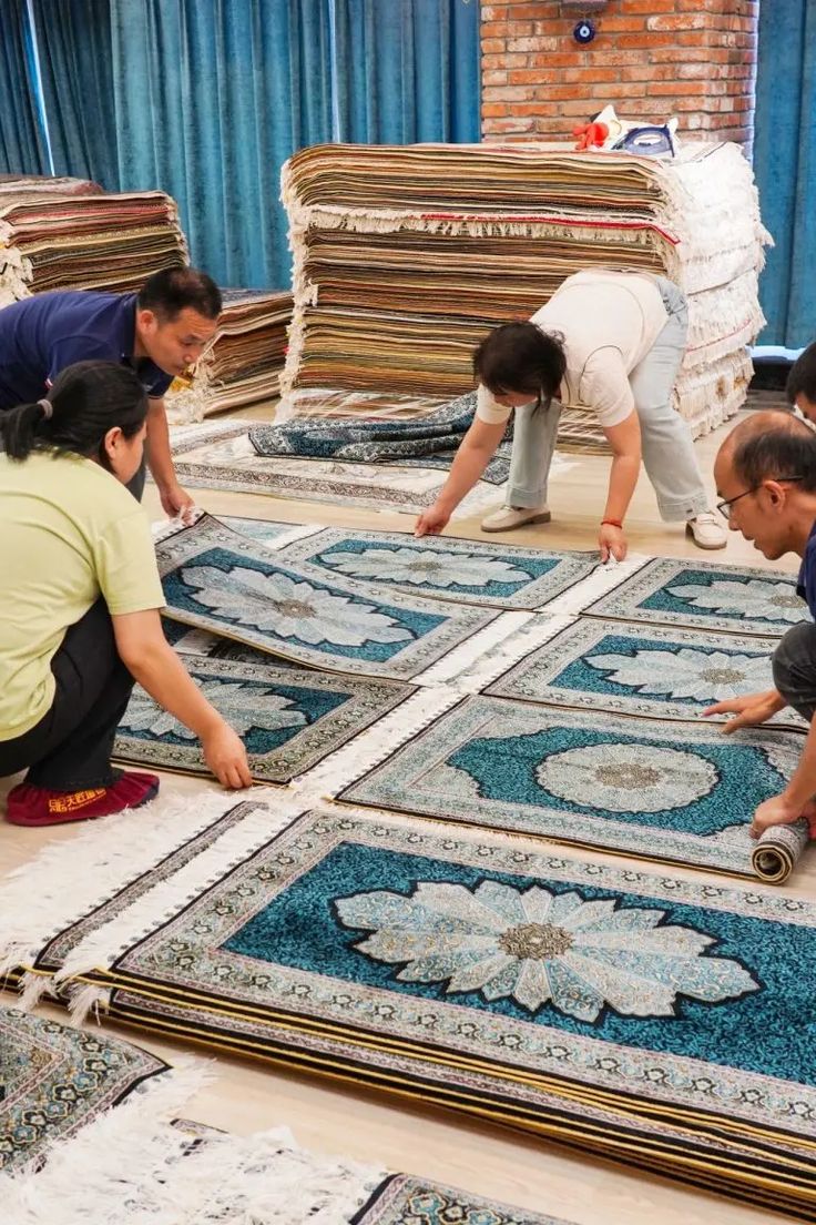 three people working on rugs in a room