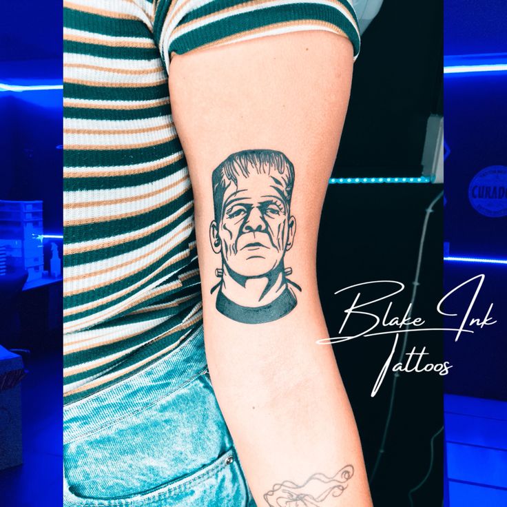 a woman with a tattoo on her arm that has an image of a man's face