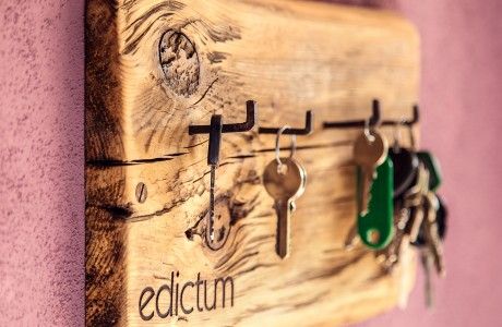 a wooden key holder with keys hanging from it's sides and the word edicctum written on it